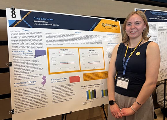 Alexandra Hehn posing for the photo in front of her poster