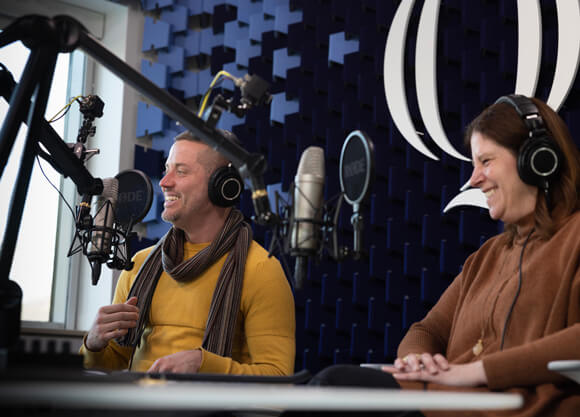 JT Torres and Karen Majeski in the podcast studio talking into microphones