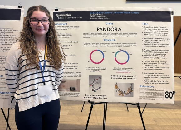 Student standing in front of poster