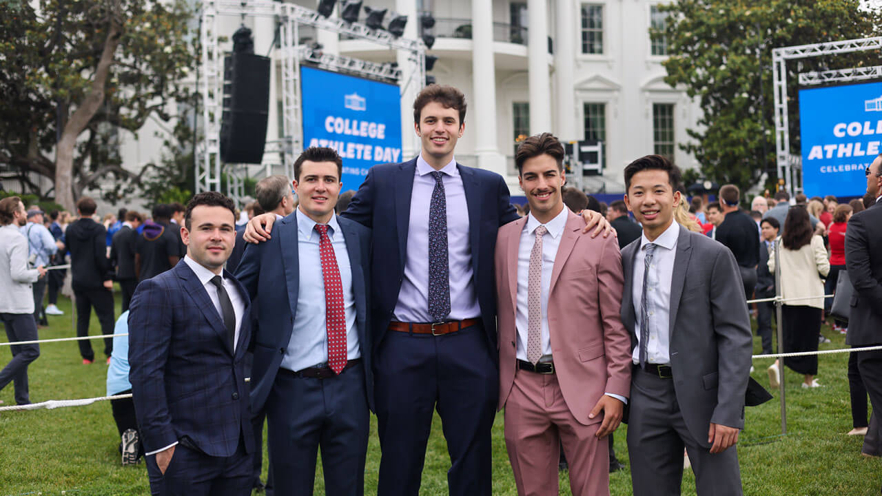Hockey players proudly stand in front of White House with College Athlete Day Signs