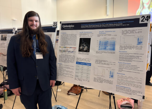 Zachary Dougan standing in front of poster