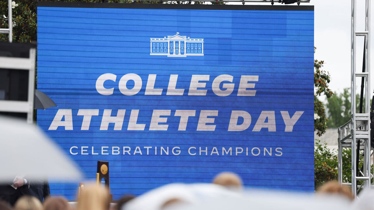 College Athlete Day poster waving in bright blue by the White House