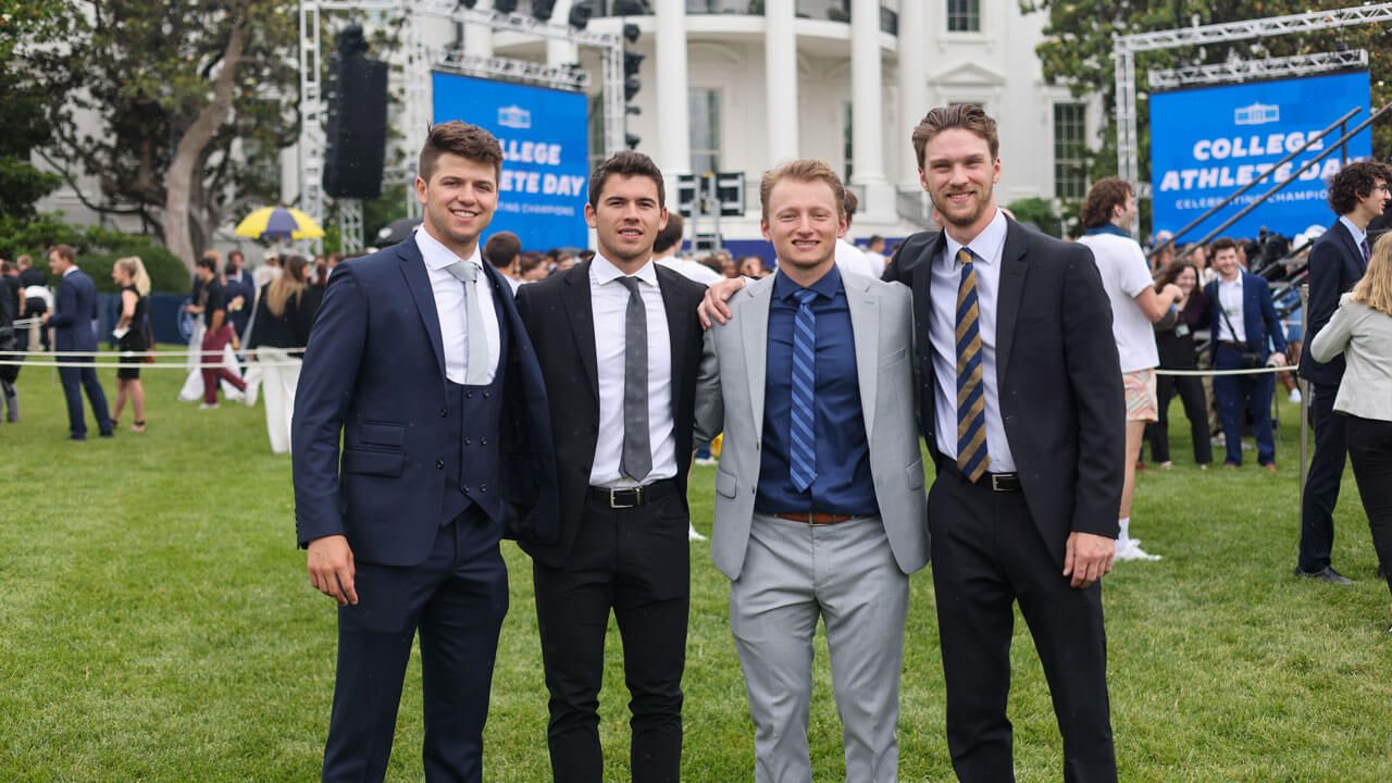 Hockey Captain cheerfully smiling and posing with teammates in front of the White House
