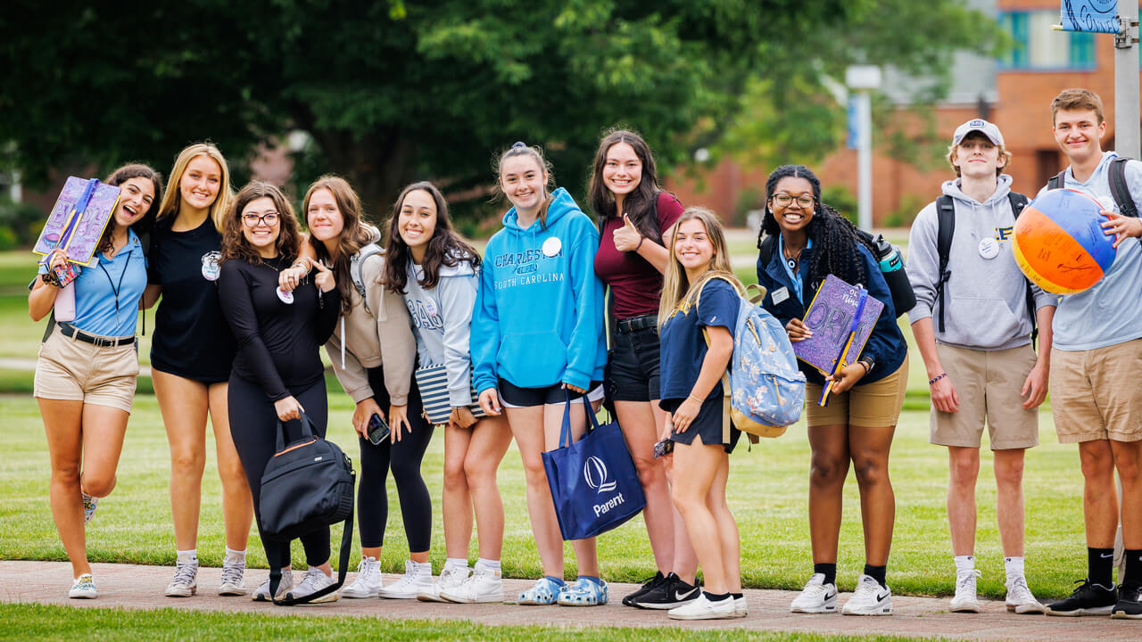 An Orientation group poses and smiles for a photo on the quad