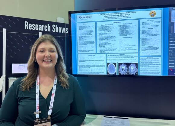 Photo of Caroline Butt standing in front of TV screen displaying poster project