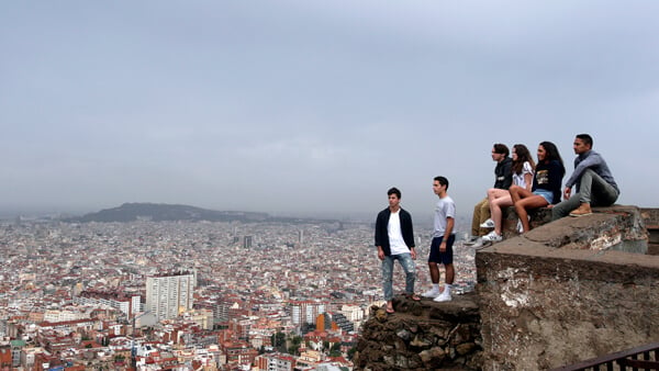 A group of Quinnipiac students stand on a ledge high above the city of Barcelona, Spain