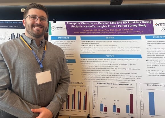 Jack Crowley standing in front of poster