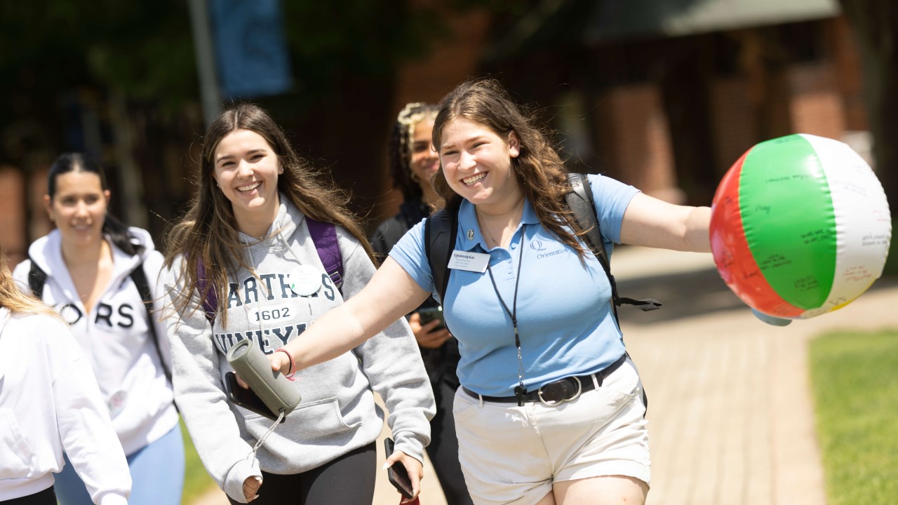 An orientation leader leads her group across campus.