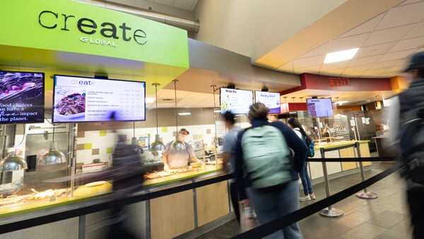 Students walk by the Create Global dining station in the Mount Carmel Campus cafe