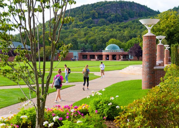 Students walk across campus on a summer day.