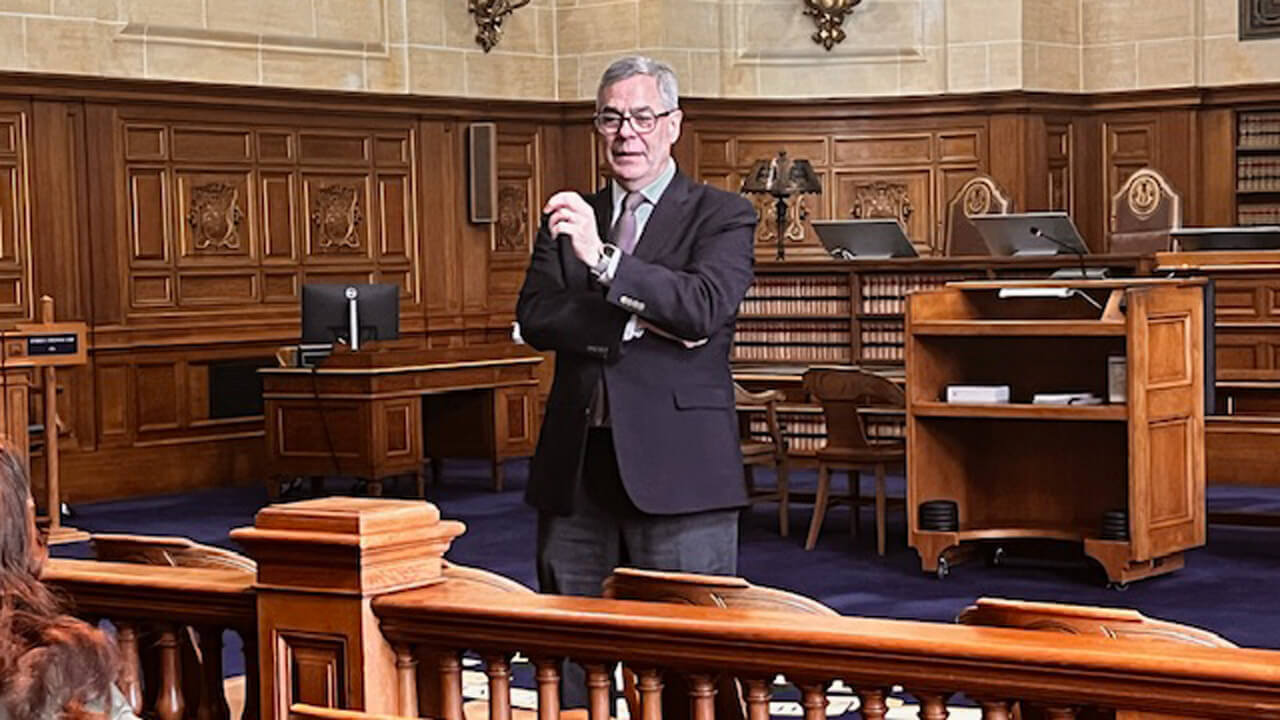 Justice Bright speaks at the front of the courtroom.