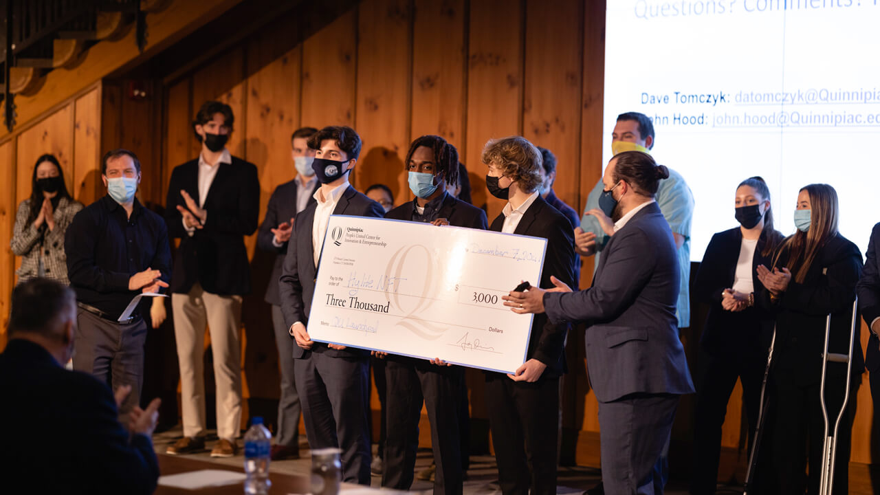 "Hylite NFT" is handed a check for $3,000 from the People's United Center for Innovation and Entrepreneurship at the 2021 Launchpad Competition.