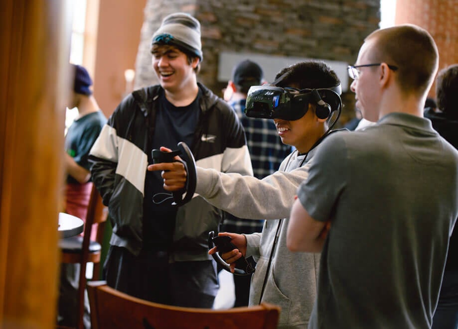 Game design and development students use a virtual reality headset.