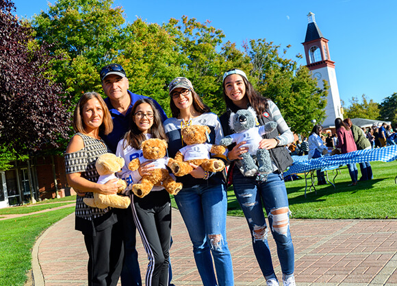 Student and her family members hold teddy bears on the quad during Bobcat Weekend