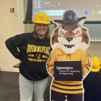 SeSe Allerheiligen in a hard hat posing with Boomer the Bobcat