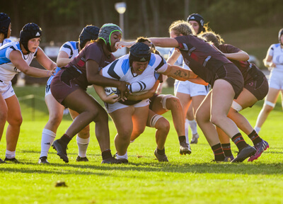 Quinnipiac women's rugby players in a scrum with another team