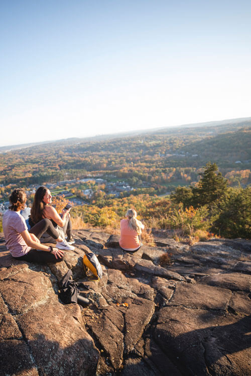 Students overlook a view of the Quinnipiac campus and Hamden from Sleeping Giant