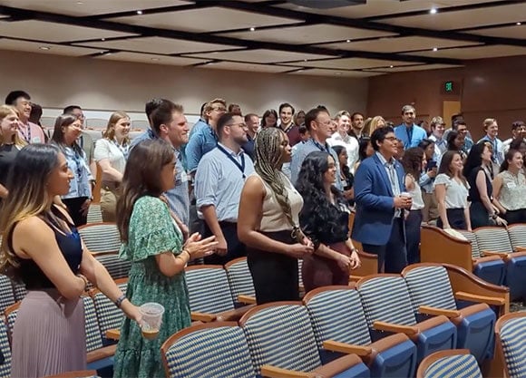 School of Medicine students stand in an auditorium