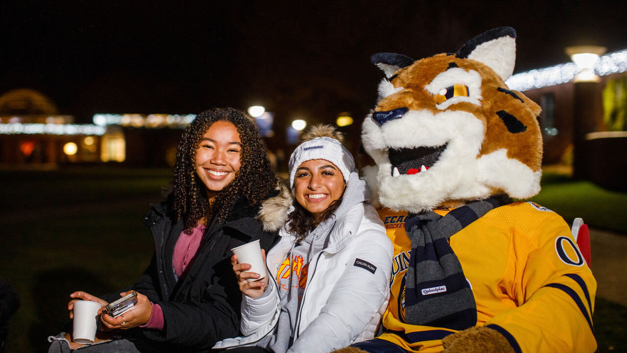Students sitting in sleigh with Boomer the Bobcat