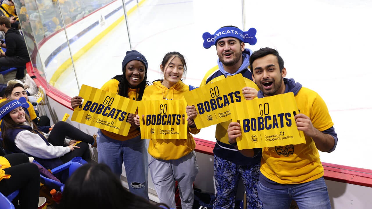 Students holding up gold "Go Bobcats" sign