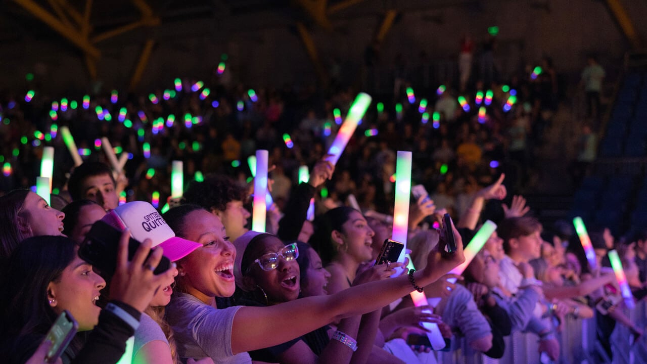 Crowd holding glow in the dark lights and cheering