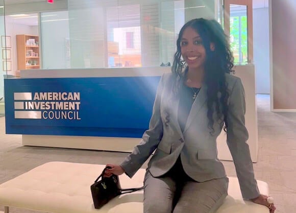 Jailyn Maldonado sitting on couch in front of American Investment Council sign