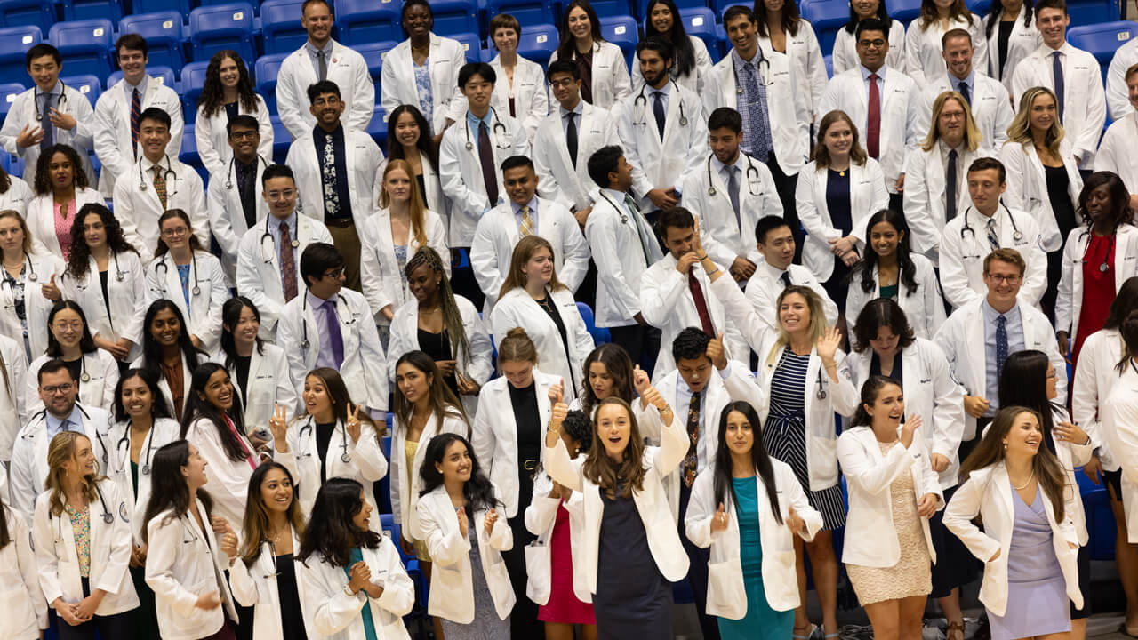 The entire Class of 2027 medical student class smile for a group photo and wave