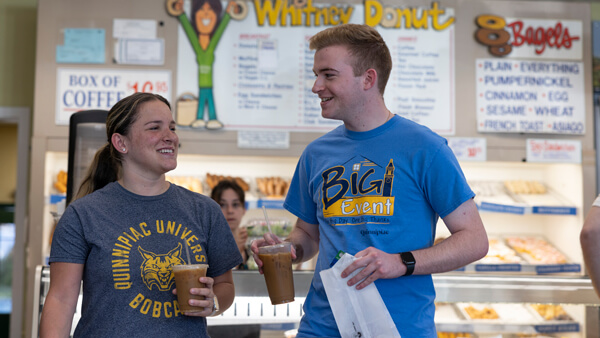 Two students buy iced coffee and donuts in Whitney Donut Shop