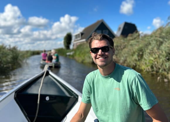 Dylan Cohen smiling on a boat with sunglasses on