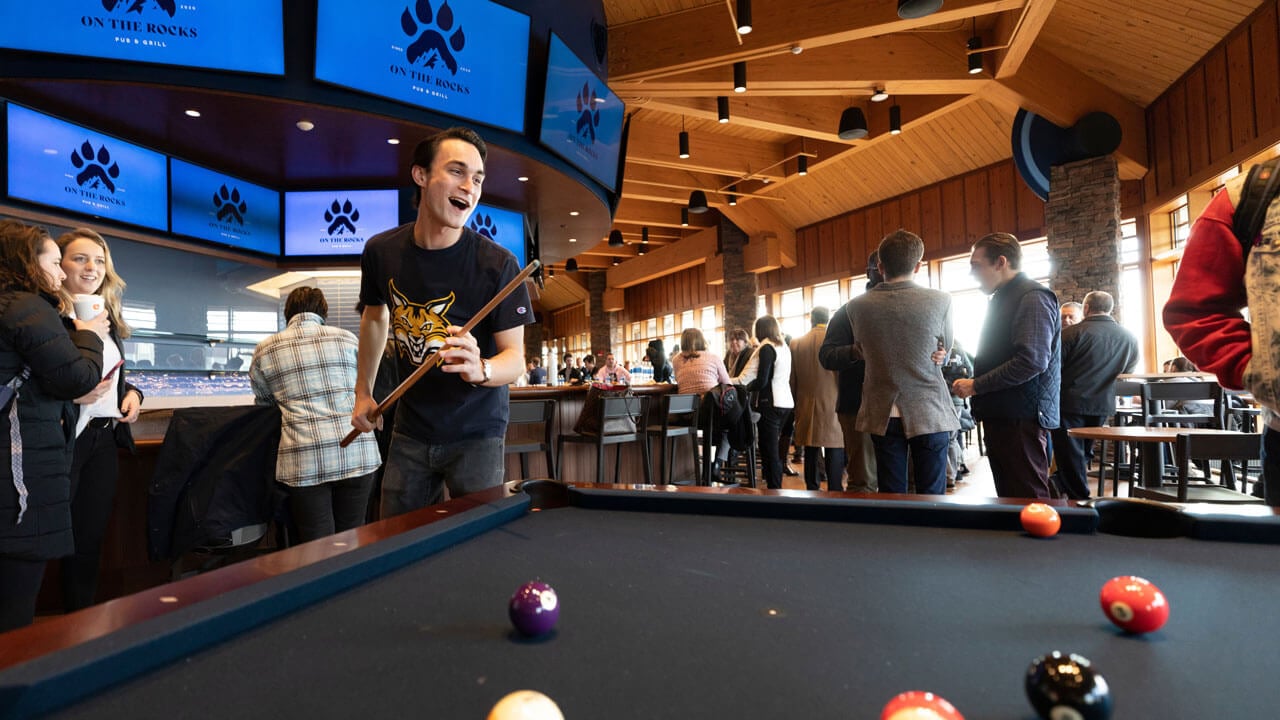 A student cheers after hitting a ball during pool