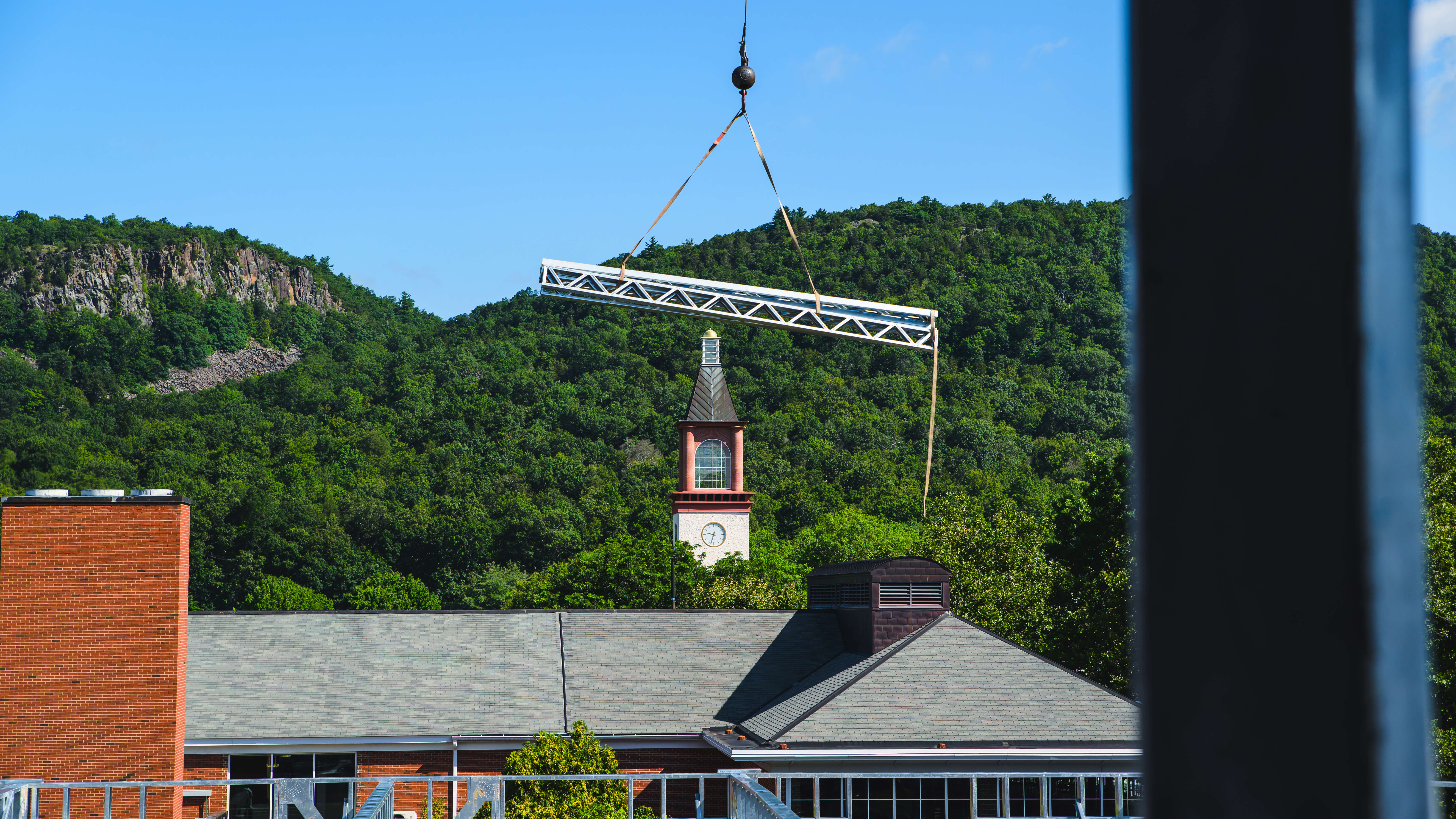 A beam gets raised with the clock tower in view