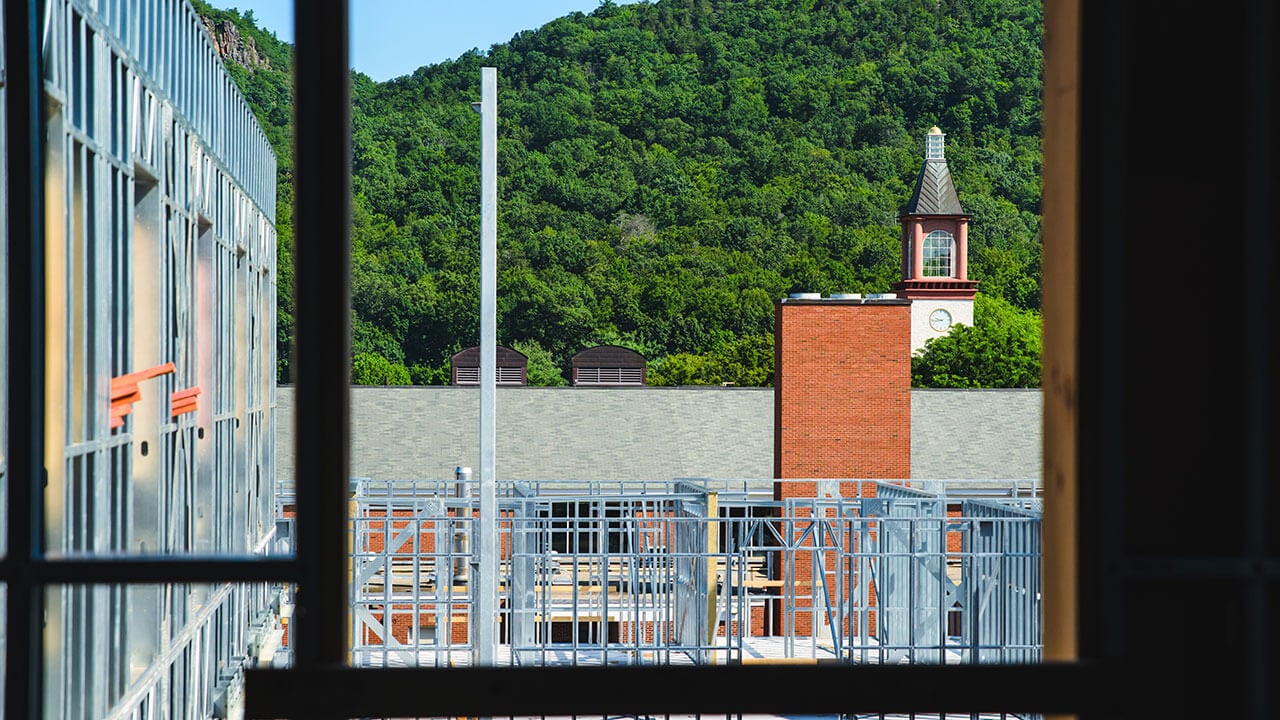 Beams hang in front of the clocktower during the South Quad construction
