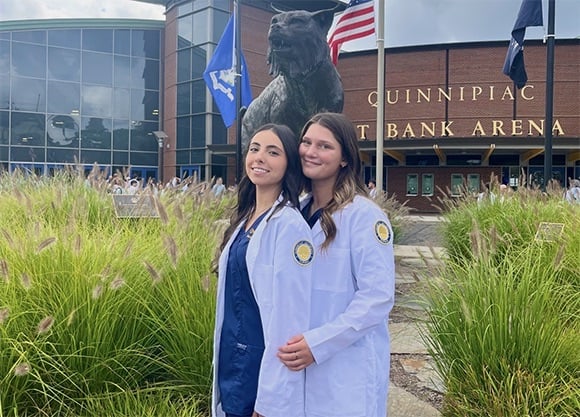 Brianna Angiolillo '27 and Shannon Fox '27 outside the M&T Bank Arena in their white coats