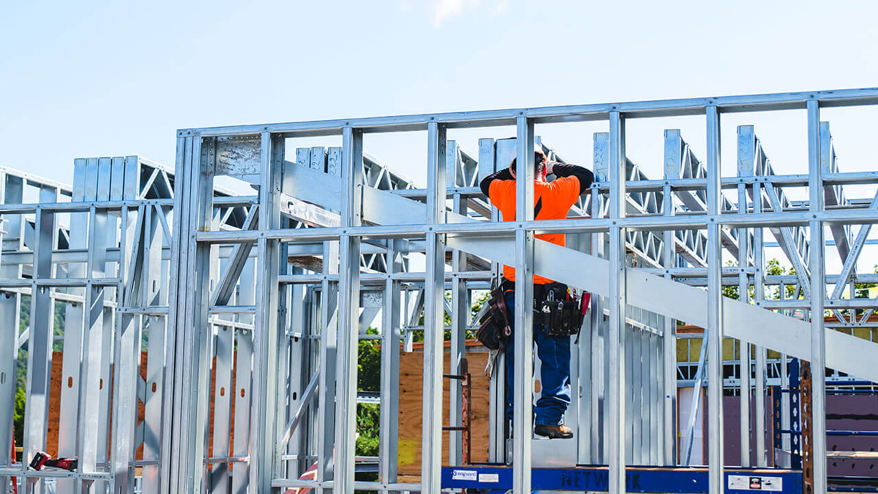 A construction worker stands on a newly built structure