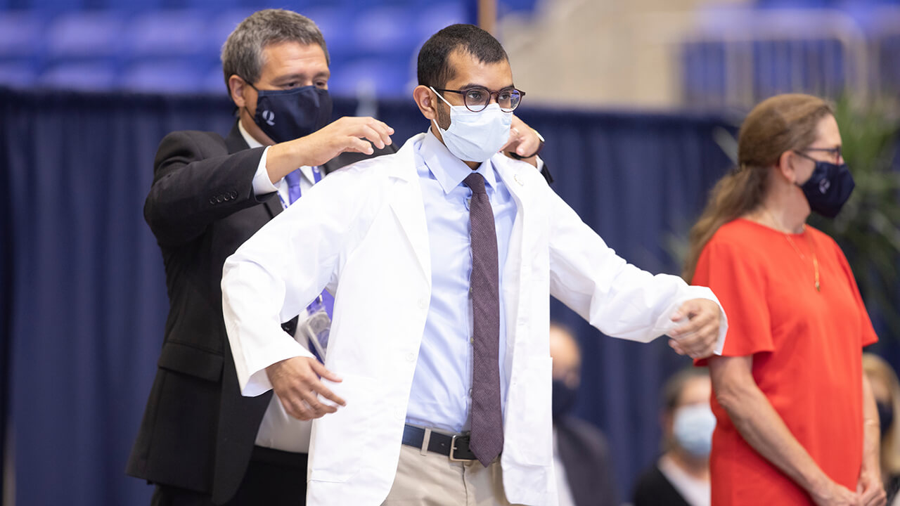 A student receives his white coat.