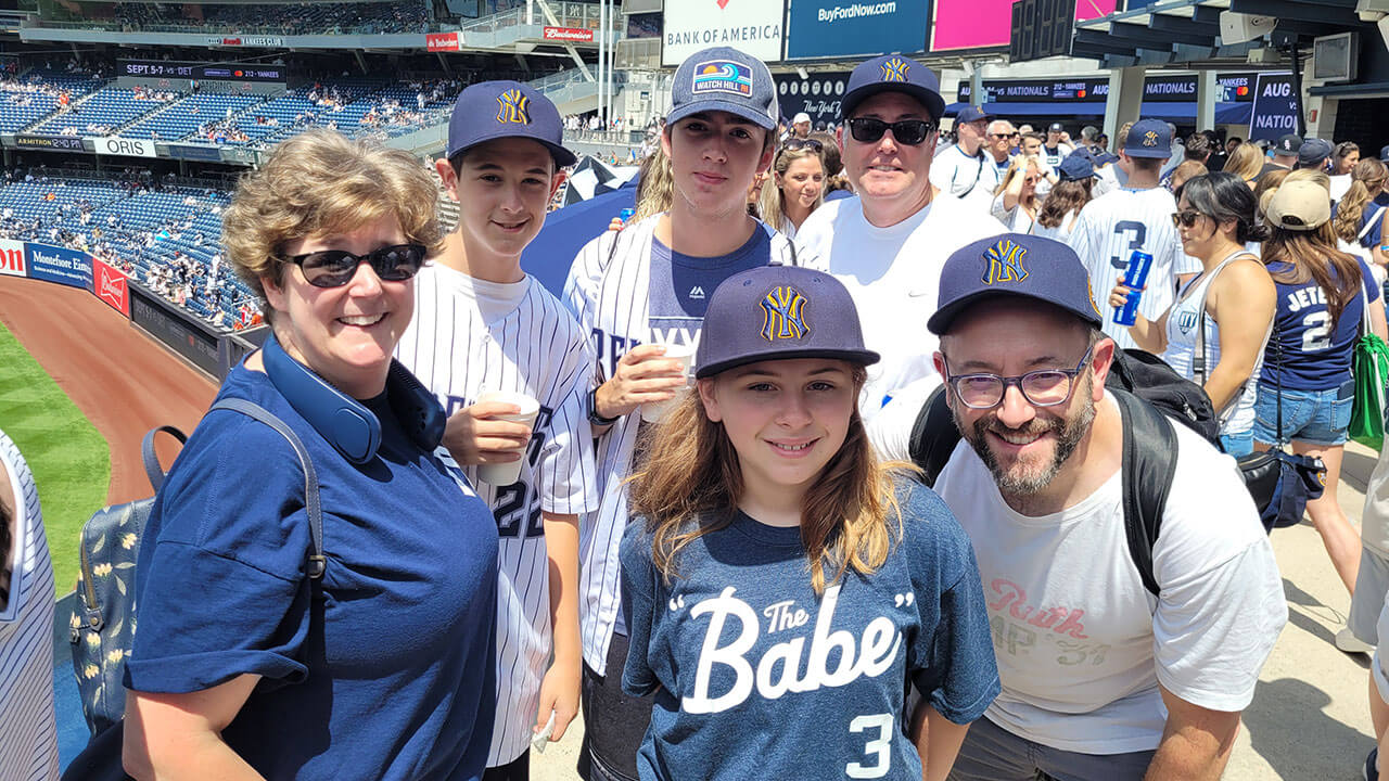 A group of alumni smile for a photo at Yankee Stadium