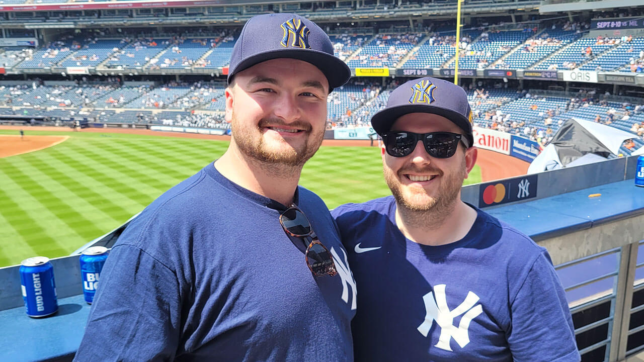 Alumni smile with excitement at Yankee Stadium during an alumni event