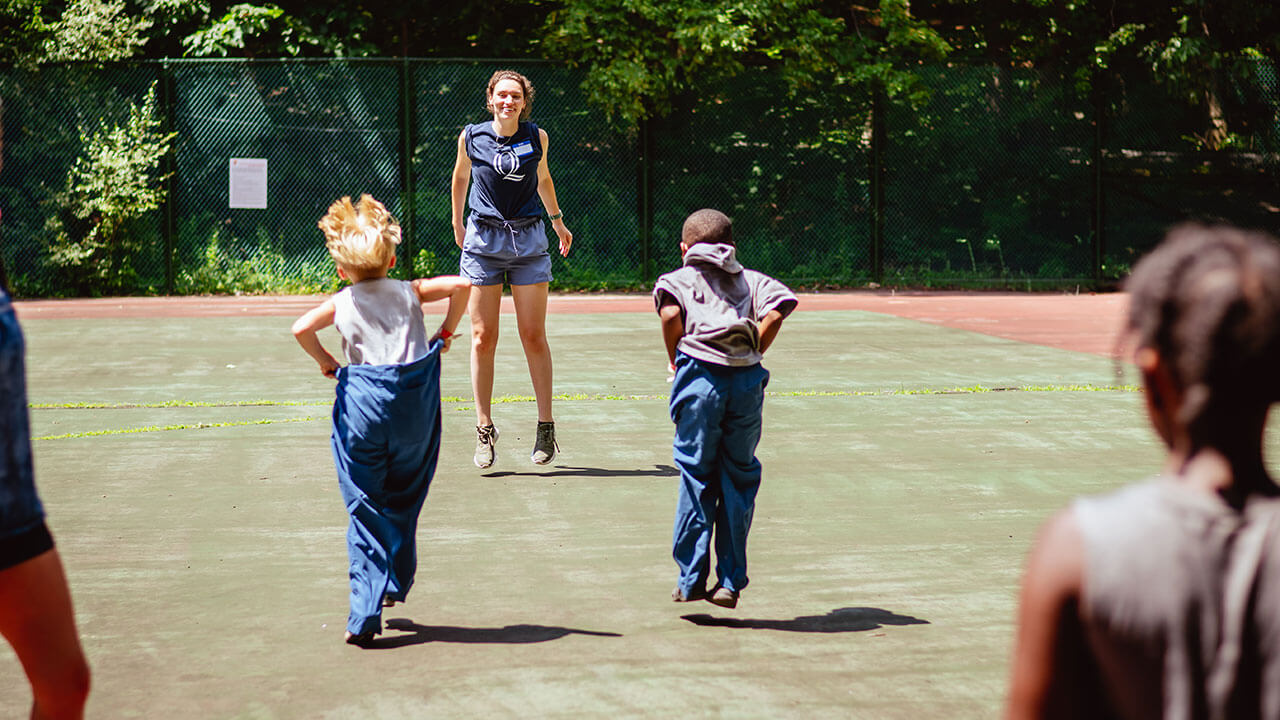 Campers run and play games during a field day