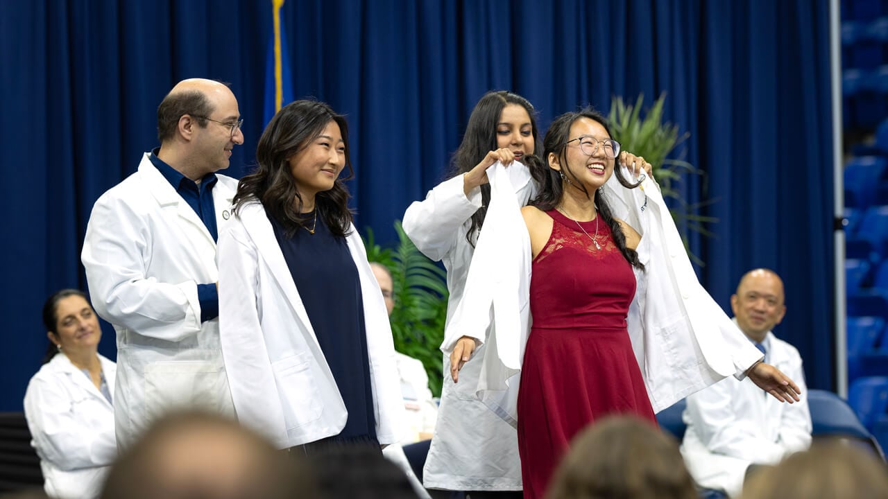People receive their white coats