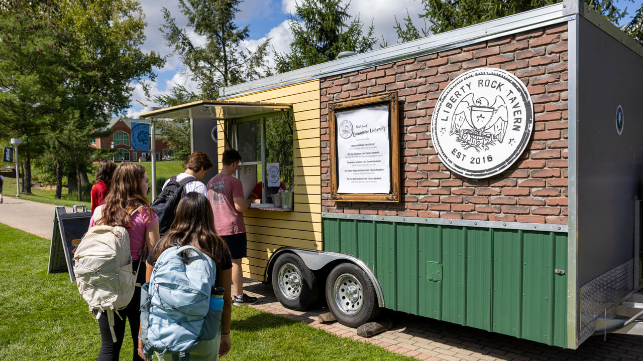 A line forms for a food truck that is parked on the quad