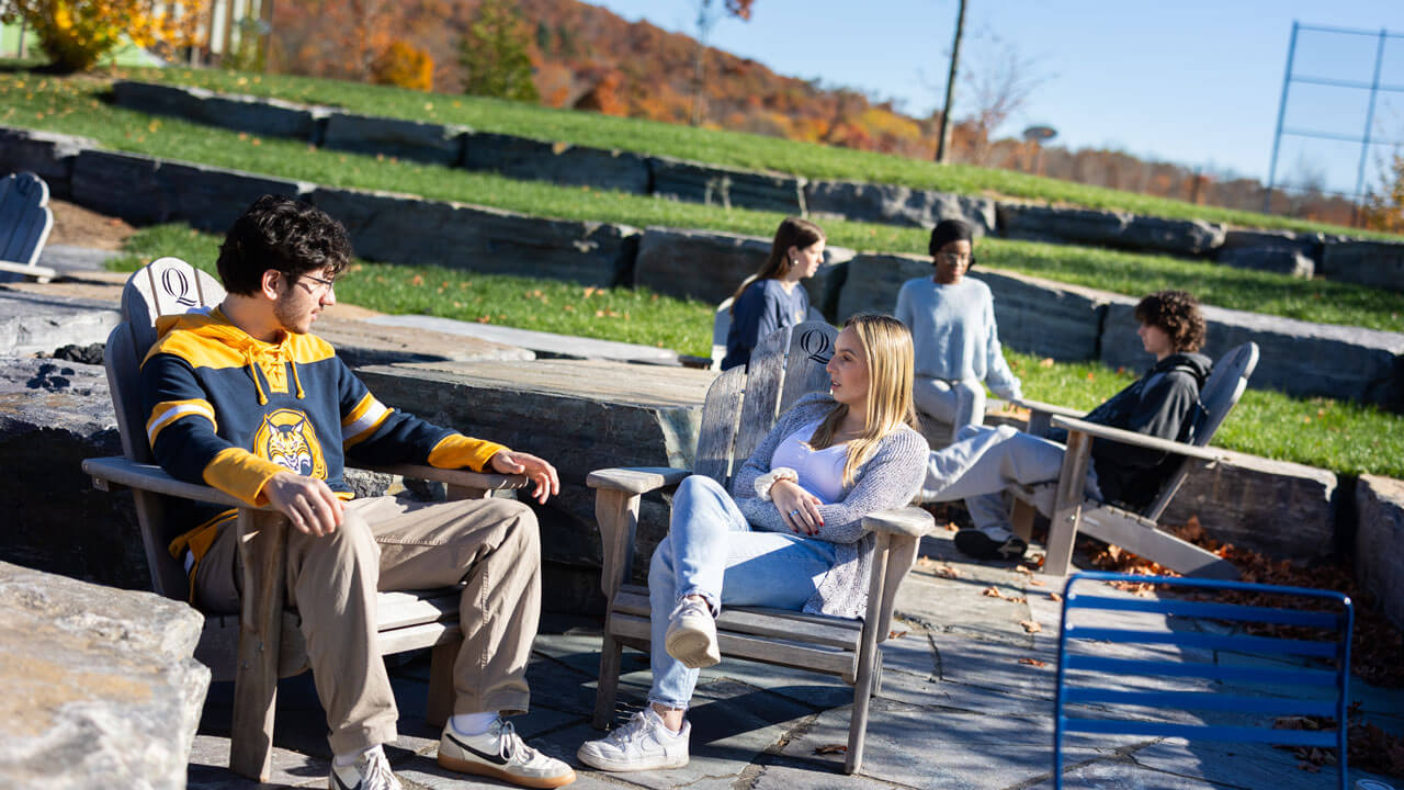Students sitting outside of recwell talking