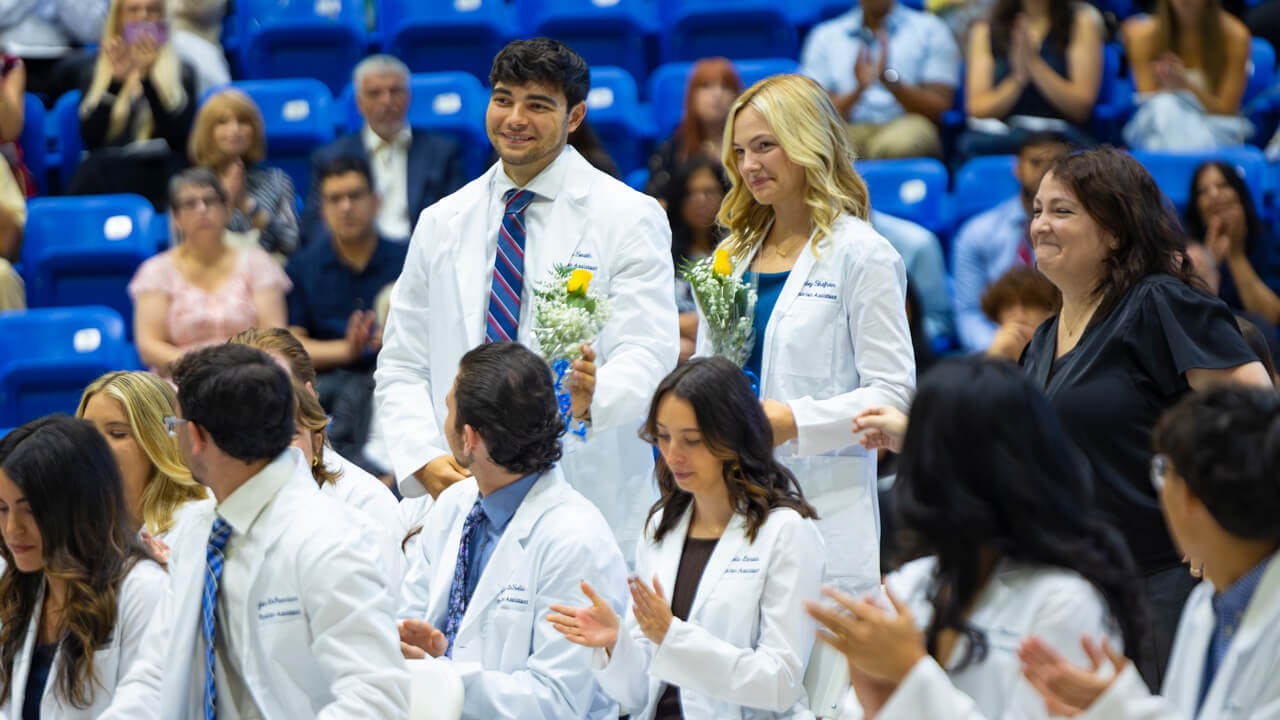 Students standing and holding flowers