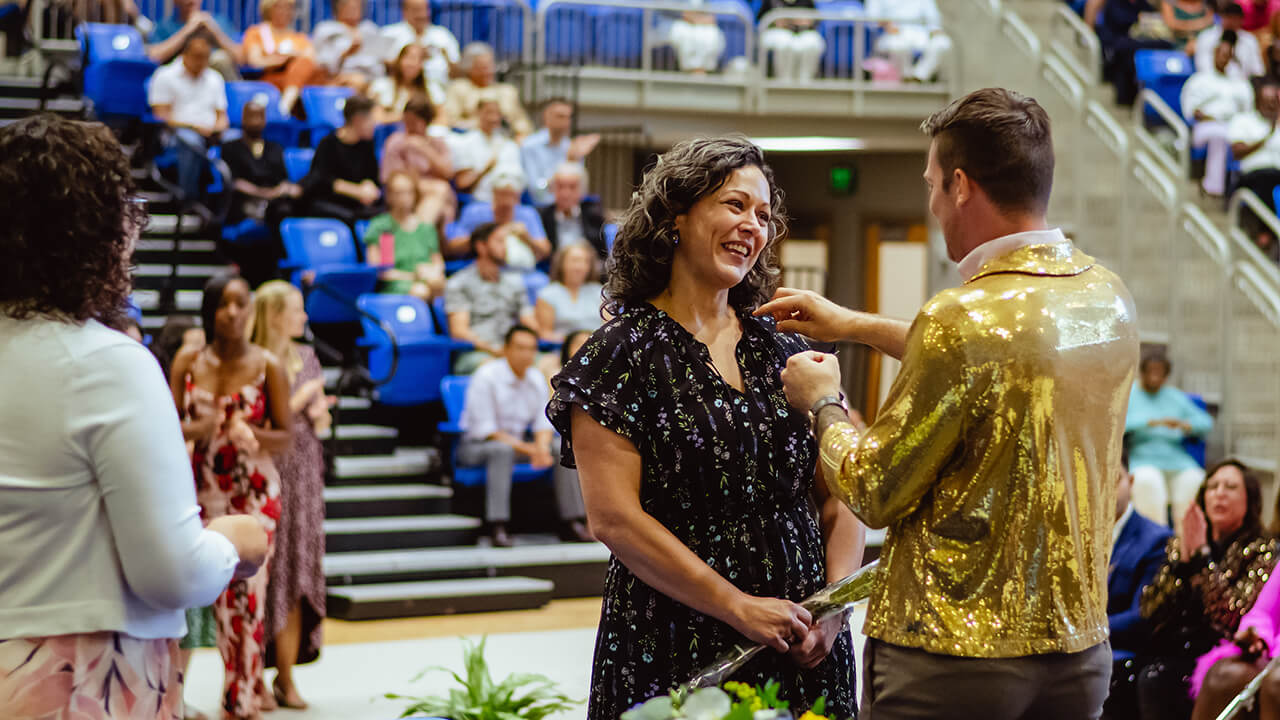 A graduating accelerated nursing student receives her pin.