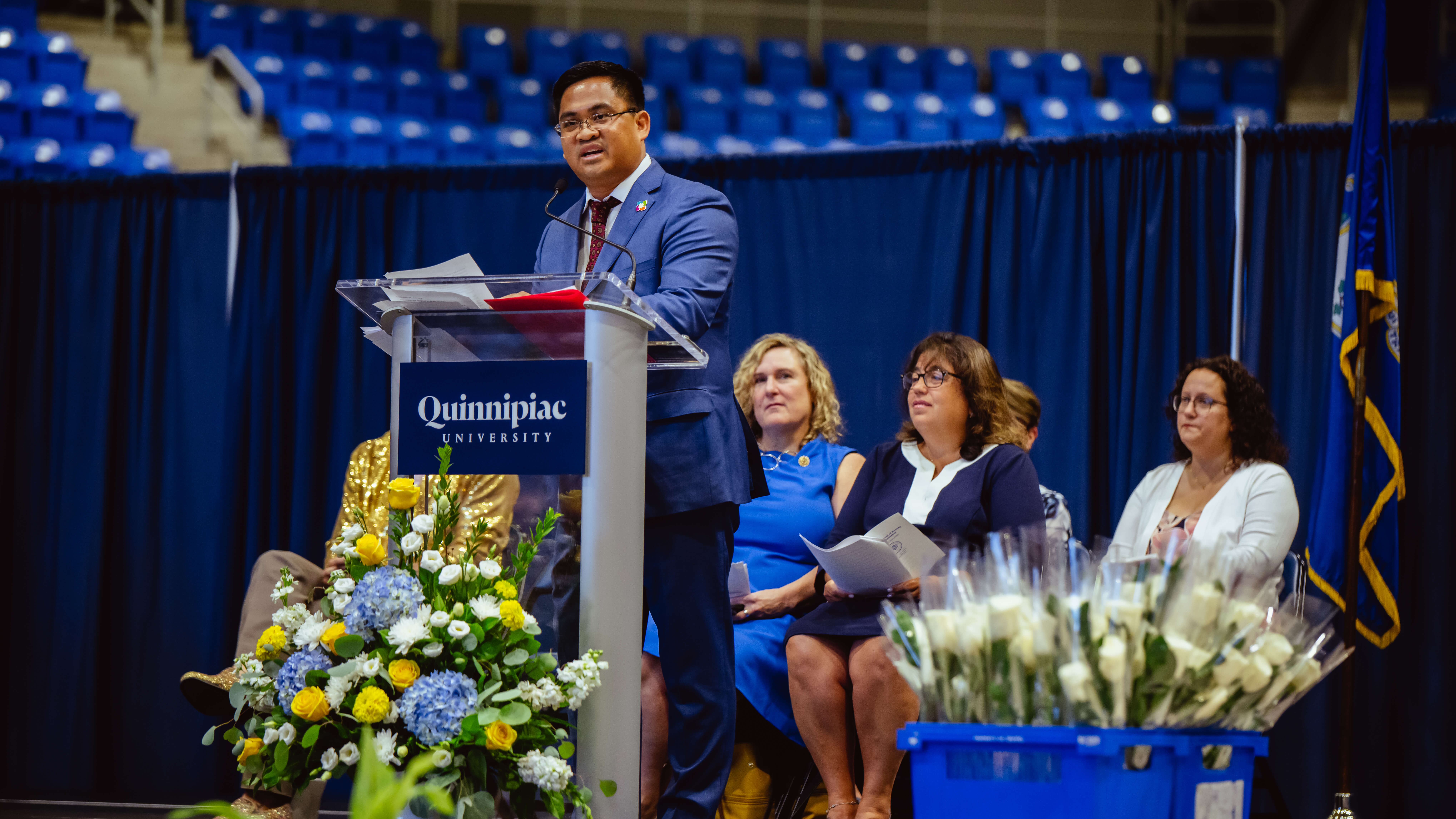 Speakers stand on stage and address the Class of 2023