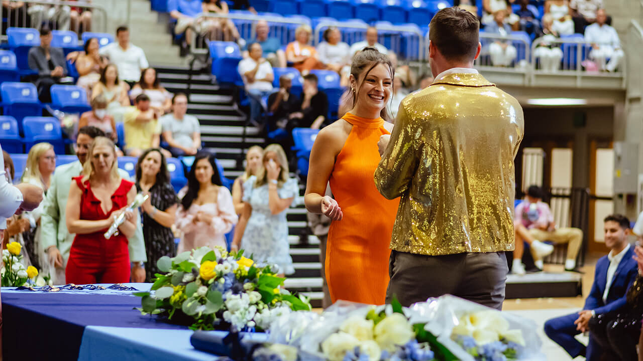 A student receives her pin on stage