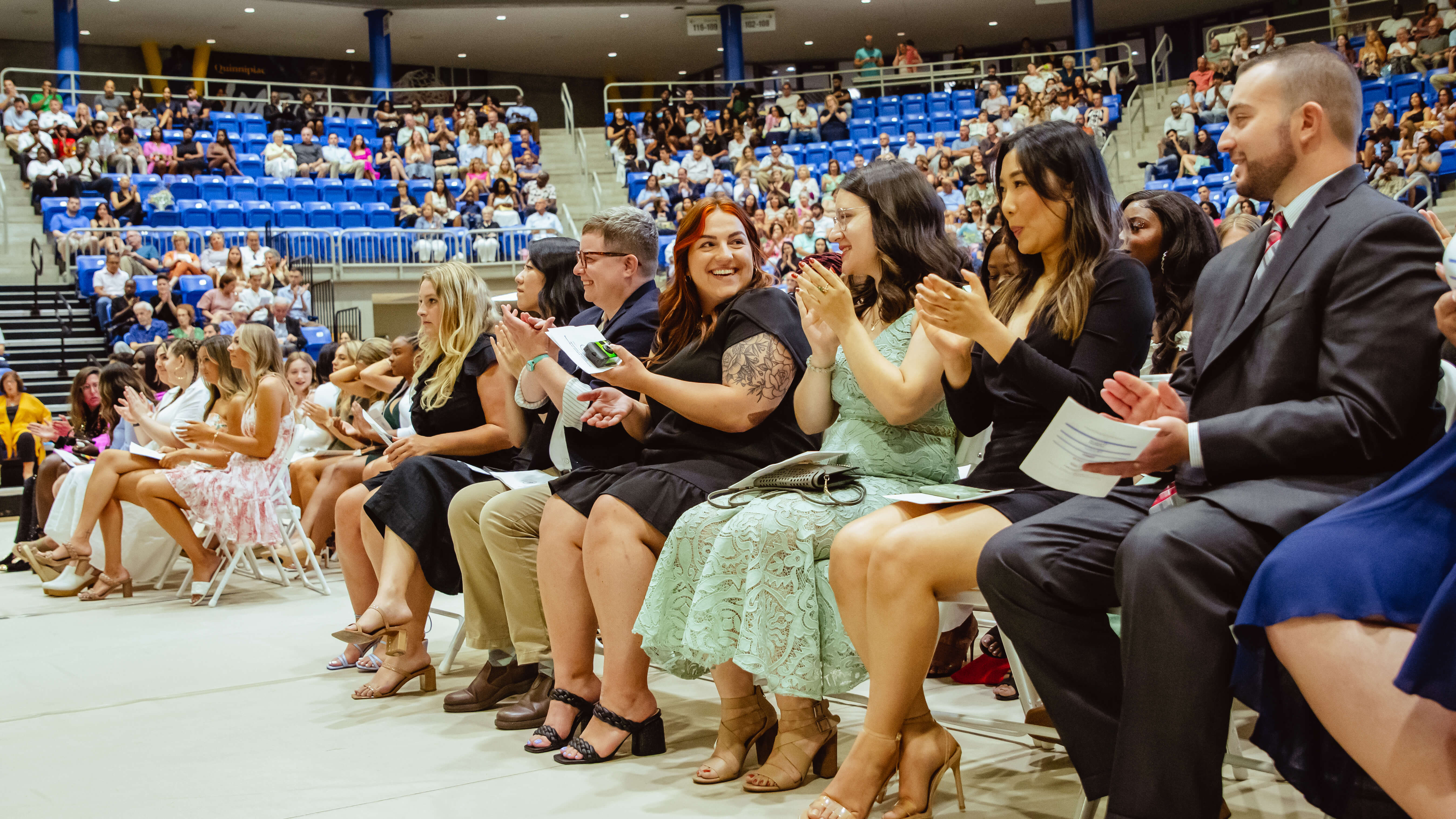 Graduates clap in their seats during the Pinning Ceremony