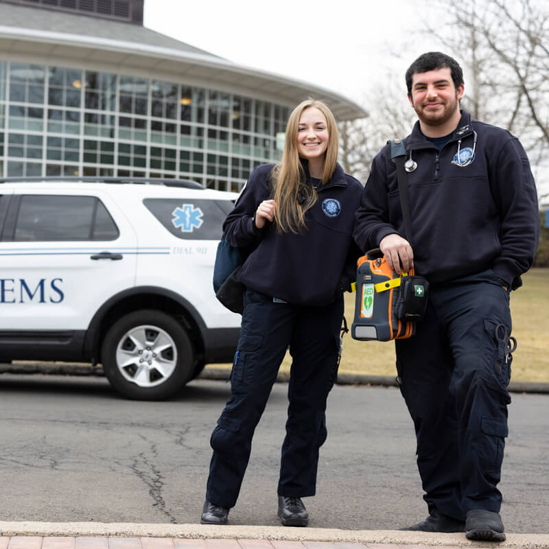 Two emergency medical services providers smile wearing their uniforms