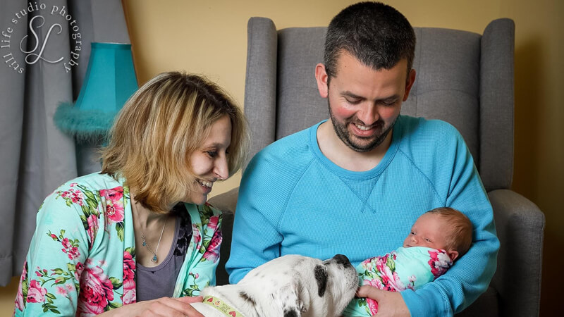 Rachel Turner and her husband sit with their dog  as they hold their baby daughter