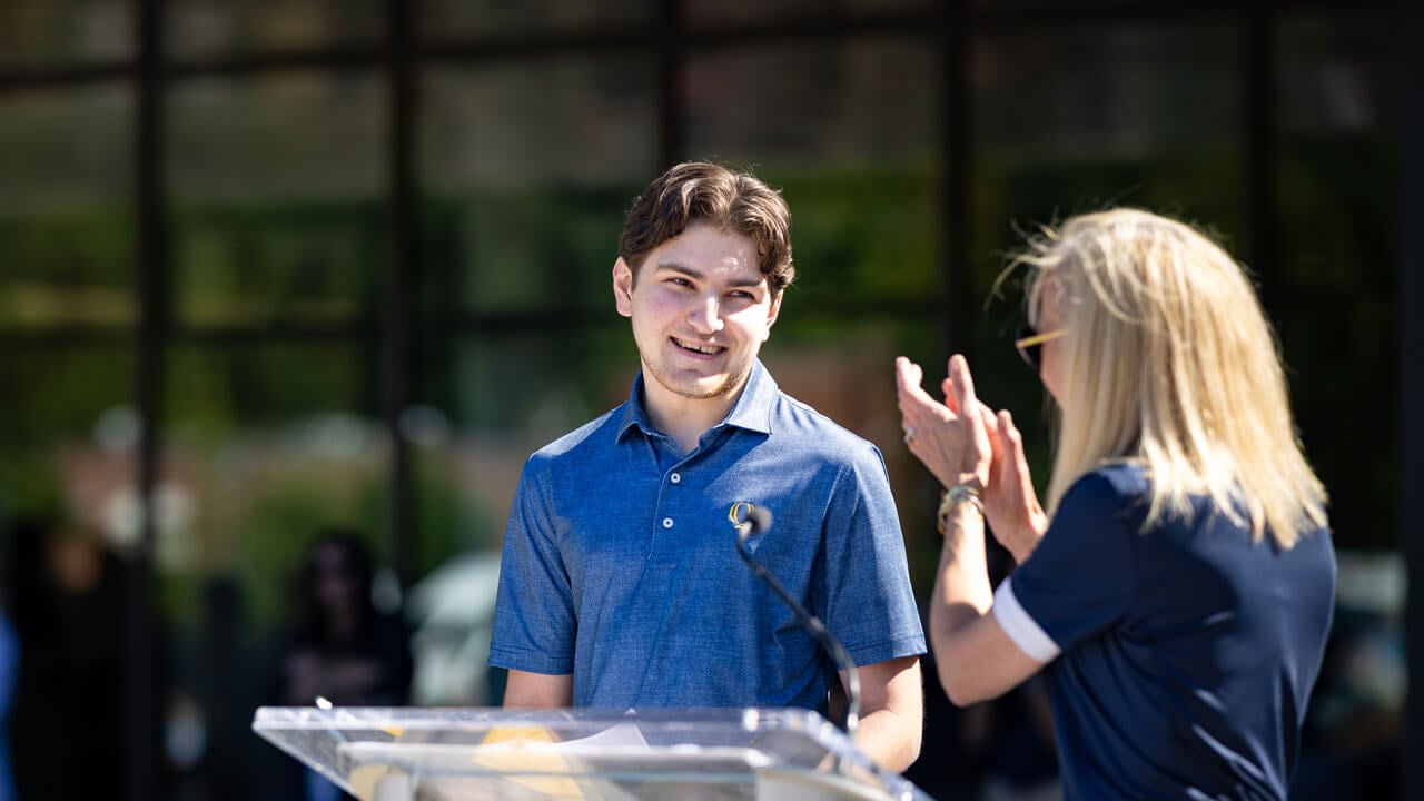President Marie Hardin praises a student speaker at the podium