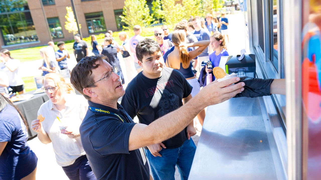 Staff member reaches for ice cream from an ice cream truck